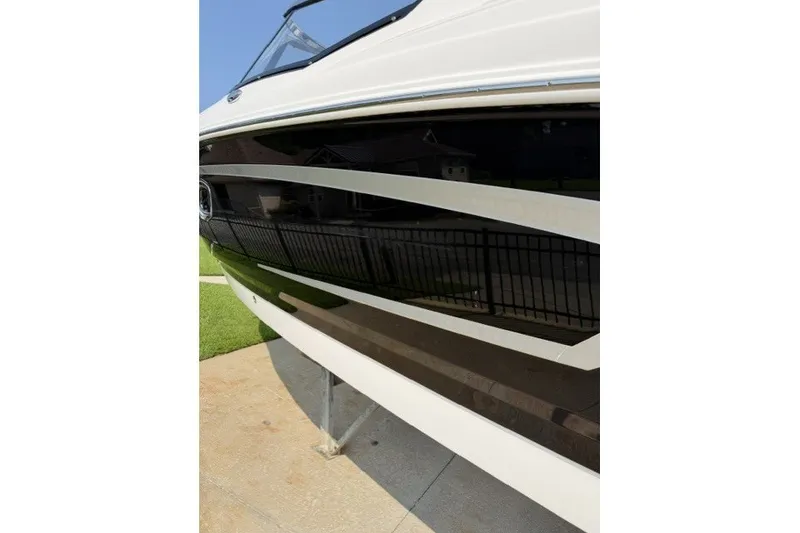 Slide: The Image of 2015 Chaparral 257 SSX boat side view with sleek black and white design. - 19