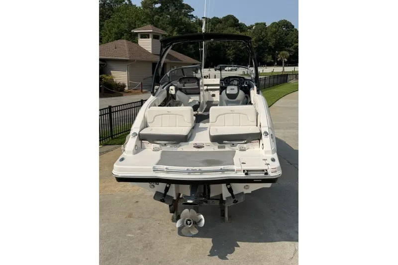 Slide: The Image of 2015 Chaparral 257 SSX boat, rear view, parked on concrete, showcasing seating and engine. - 3