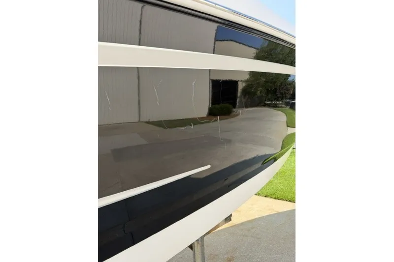 Slide: The Image of 2015 Chaparral 257 SSX boat hull with visible scratches and reflections. - 18
