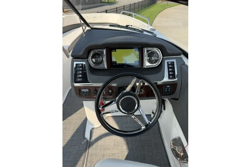 Slide: The Image of 2015 Chaparral 257 SSX boat dashboard with steering wheel and navigation display. - 5