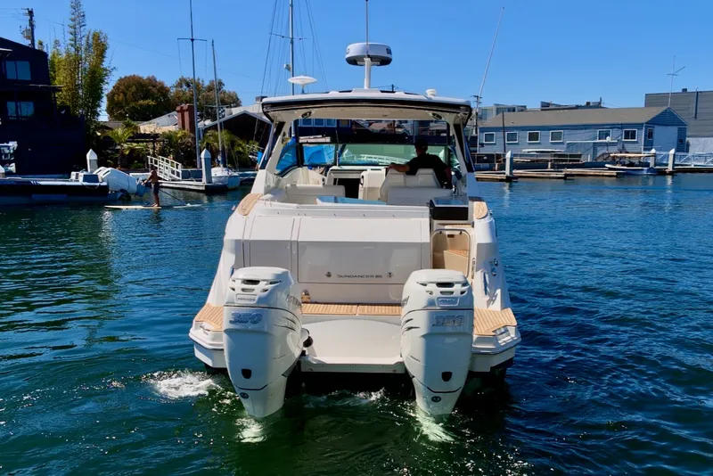 Slide: The Image of A 2021 Sea Ray Sundancer 320 Outboard on the water, featuring twin outboard engines. - 7