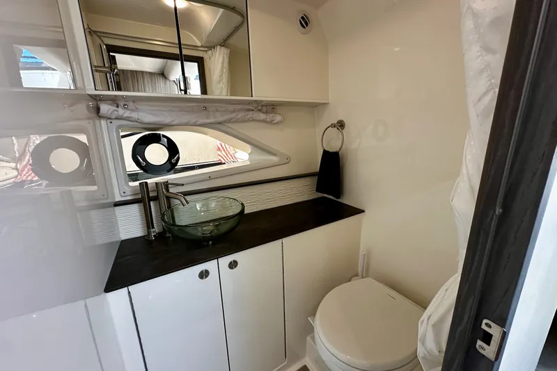 Slide: The Image of The image shows a modern boat bathroom with a sink, mirror, and toilet. - 32