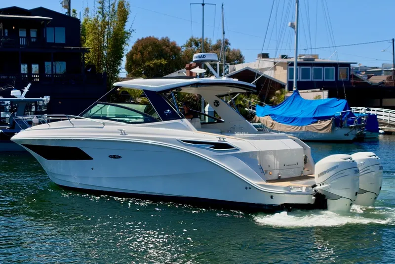Slide: The Image of A sleek, modern motorboat with two outboard engines cruising through a calm harbor. - 5