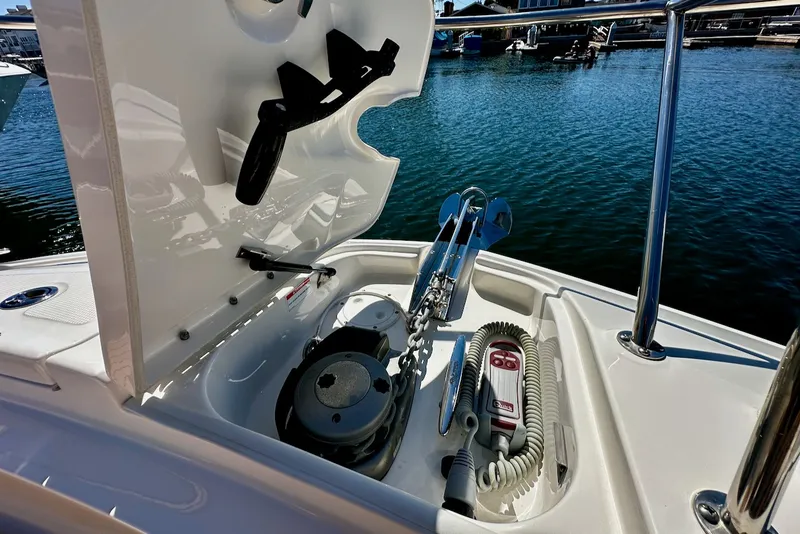 Slide: The Image of An anchor compartment on a boat with windlass and rope, surrounded by water and a marina. - 34