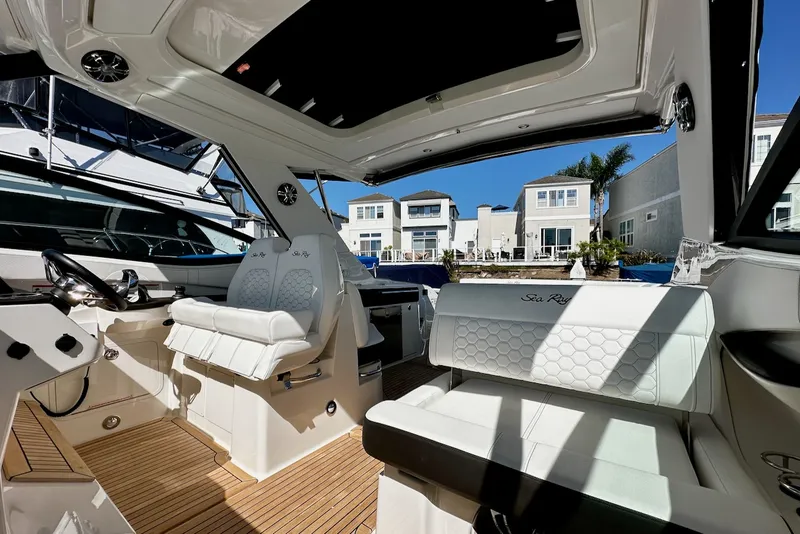 Slide: The Image of Interior view of a 2021 Sea Ray Sundancer 320 Outboard with sleek white seating and wooden flooring. - 15