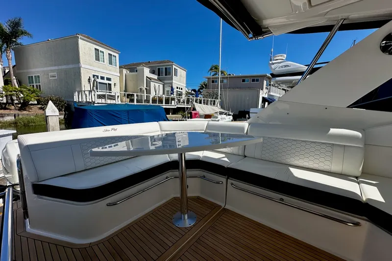 Slide: The Image of The image shows the cockpit of a Sea Ray Sundancer 320 Outboard with sleek white seating and a table. - 23