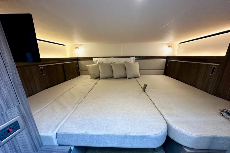 Slide: The Image of Interior of the 2021 Sea Ray Sundancer 320 Outboard with a large, cozy bed and wood accents. - 28