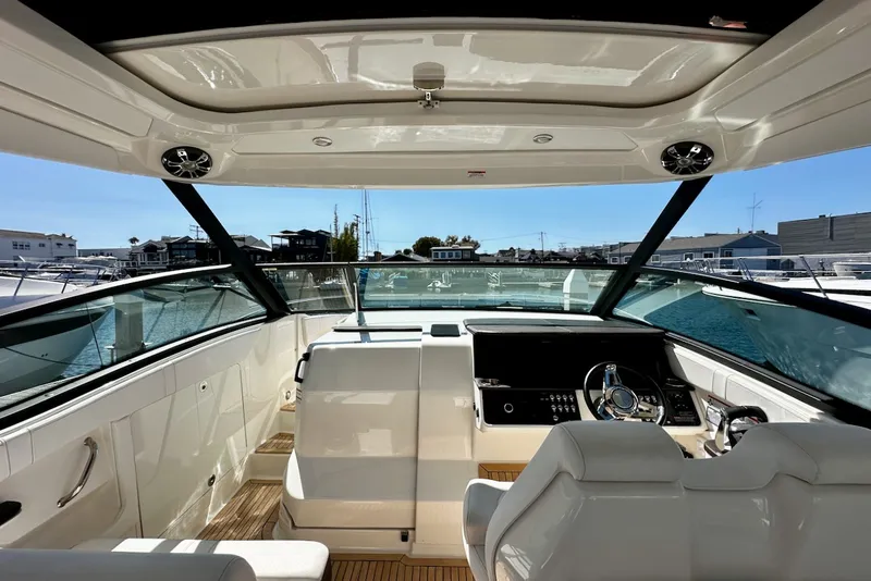 Slide: The Image of The cockpit of the 2021 Sea Ray Sundancer 320 Outboard features a modern helm and comfortable seating. - 14