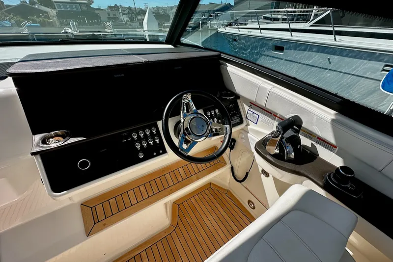 Slide: The Image of The cockpit of a 2021 Sea Ray Sundancer 320 Outboard with modern steering and instruments. - 18