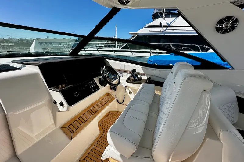 Slide: The Image of The cockpit of a 2021 Sea Ray Sundancer 320 Outboard with luxurious white seating. - 17