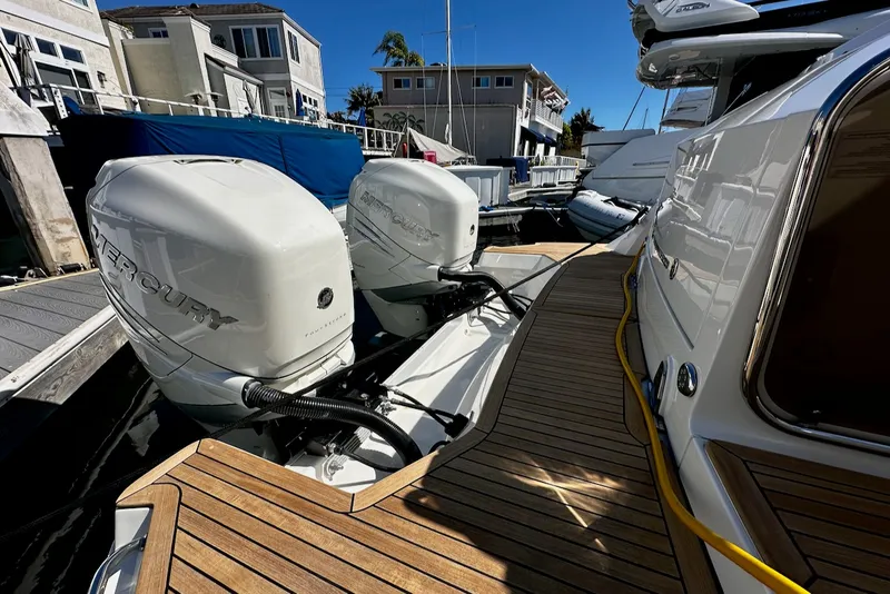 Slide: The Image of The image shows the stern of a Sea Ray Sundancer 320 Outboard with two Mercury outboard engines. - 33