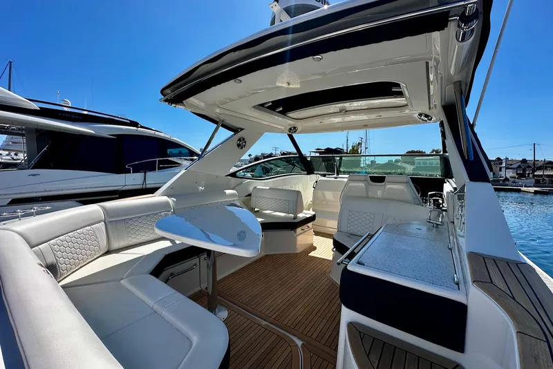 Slide: The Image of The image shows the cockpit of a 2021 Sea Ray Sundancer 320 Outboard with sleek seating and a table. - 19