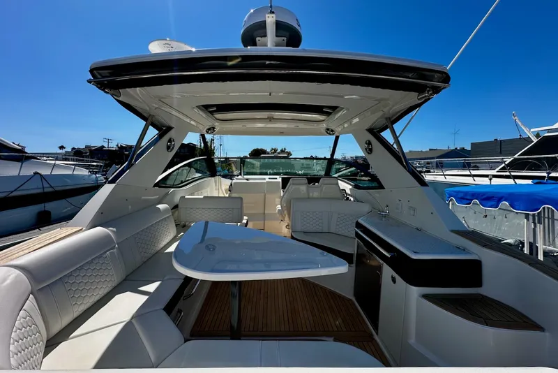 Slide: The Image of The image shows the cockpit of a 2021 Sea Ray Sundancer 320 Outboard with sleek seating and a table. - 20