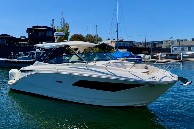 Slide: The Image of A 2021 Sea Ray Sundancer 320 Outboard is anchored in the water, surrounded by buildings. - 13