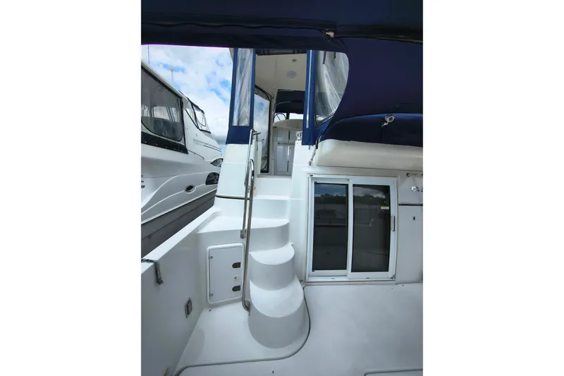 Slide: The Image of 2006 Carver 444 Cockpit Motor Yacht with stairs and sliding doors, featuring blue canopy. - 11