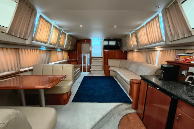Slide: The Image of Luxurious interior of 2006 Carver 444 Cockpit Motor Yacht with elegant seating and dining area. - 19