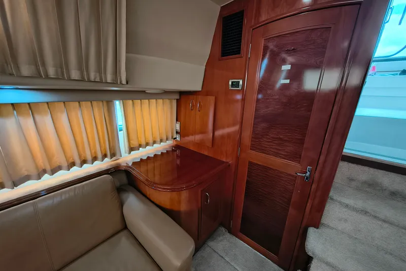 Slide: The Image of Interior of 2006 Carver 444 Cockpit Motor Yacht with wood paneling and beige seating. - 25