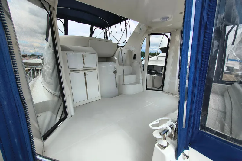 Slide: The Image of Interior view of 2006 Carver 444 Cockpit Motor Yacht with white cabinetry and blue accents. - 12