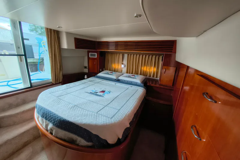 Slide: The Image of Luxurious bedroom interior of 2006 Carver 444 Cockpit Motor Yacht with nautical-themed bedding. - 30
