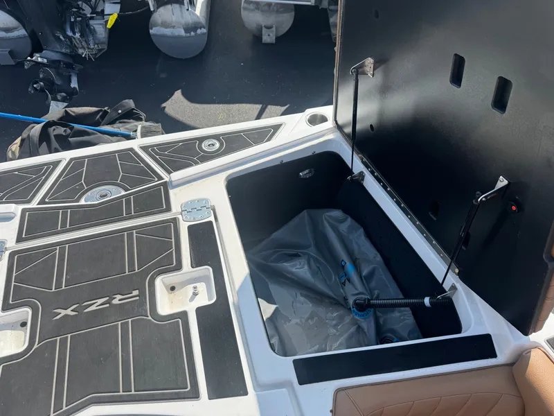 Slide: The Image of The image shows the storage compartment of a 2022 Tigé 20 RZX boat with an open lid. - 34