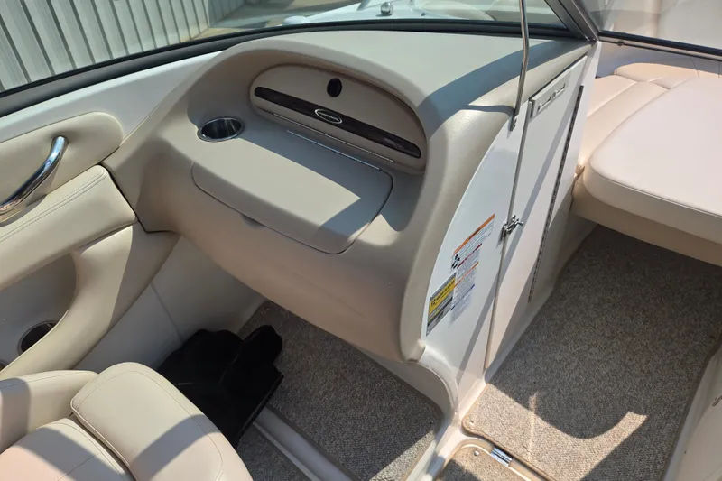 Slide: The Image of Interior of a 2006 Chaparral 220 SSi boat, featuring beige upholstery and sleek design. - 16
