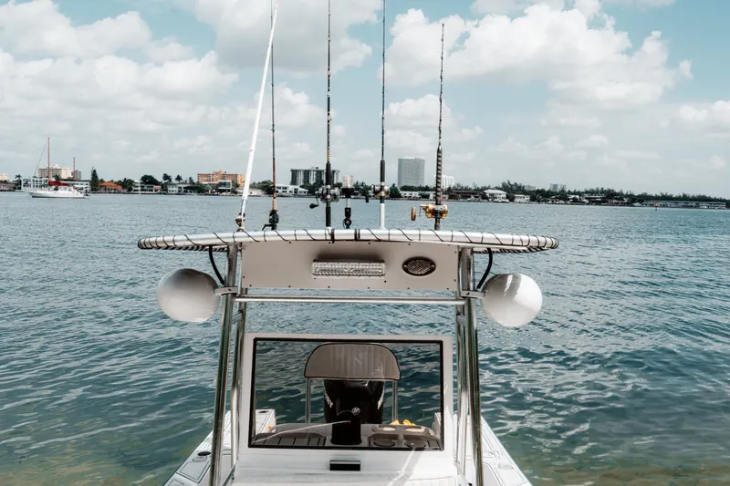 Slide: The Image of 1996 Mako 231 Center Console boat on calm water with city skyline in background. - 3