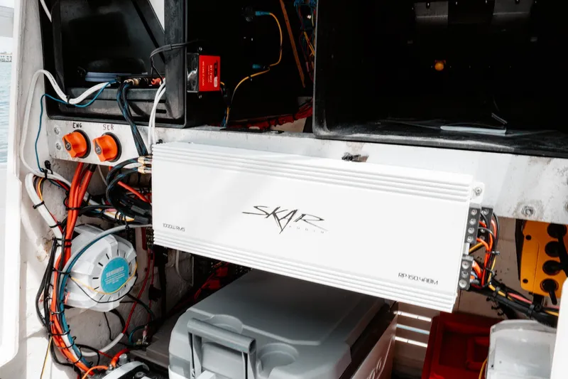 Slide: The Image of Electrical setup inside a 1996 Mako 231 Center Console boat, featuring Skar Audio amplifier. - 45