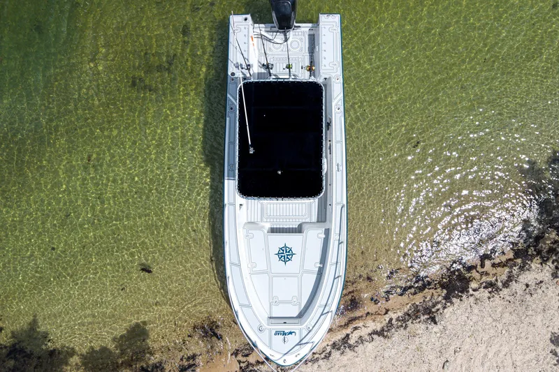 Slide: The Image of Overhead view of a 1996 Mako 231 Center Console boat on clear water near sandy shore. - 2