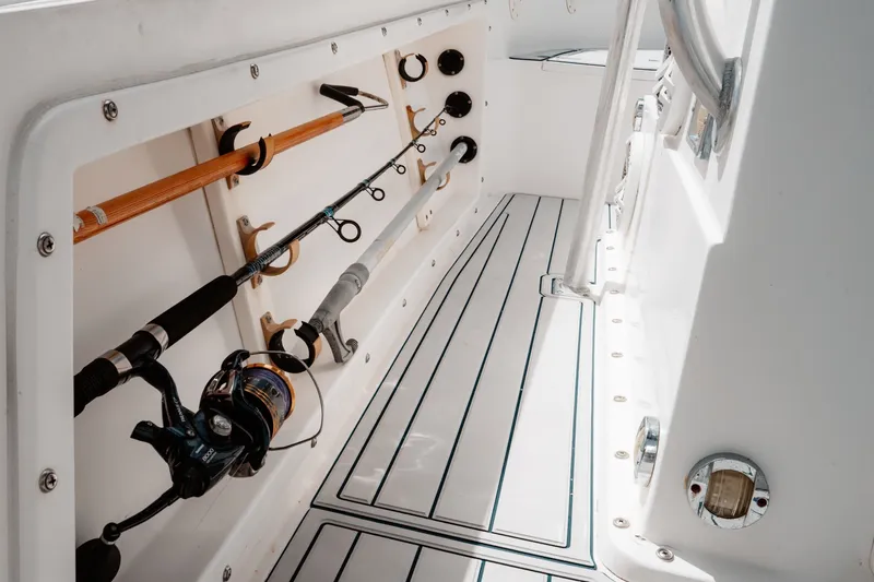 Slide: The Image of Interior of a 1996 Mako 231 Center Console boat with fishing rods stored neatly. - 24