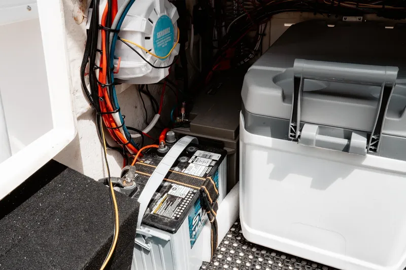 Slide: The Image of Electrical setup inside a 1996 Mako 231 Center Console boat, featuring battery and wiring. - 44