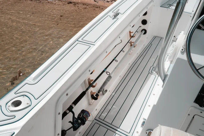 Slide: The Image of Interior view of a 1996 Mako 231 Center Console boat with fishing rod holders. - 23