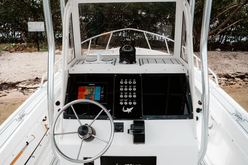 Slide: The Image of 1996 Mako 231 Center Console boat dashboard with steering wheel and navigation equipment. - 8