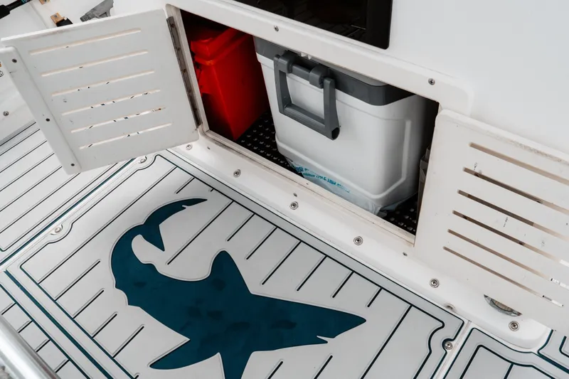 Slide: The Image of Storage compartment on 1996 Mako 231 Center Console boat with shark logo on deck. - 39
