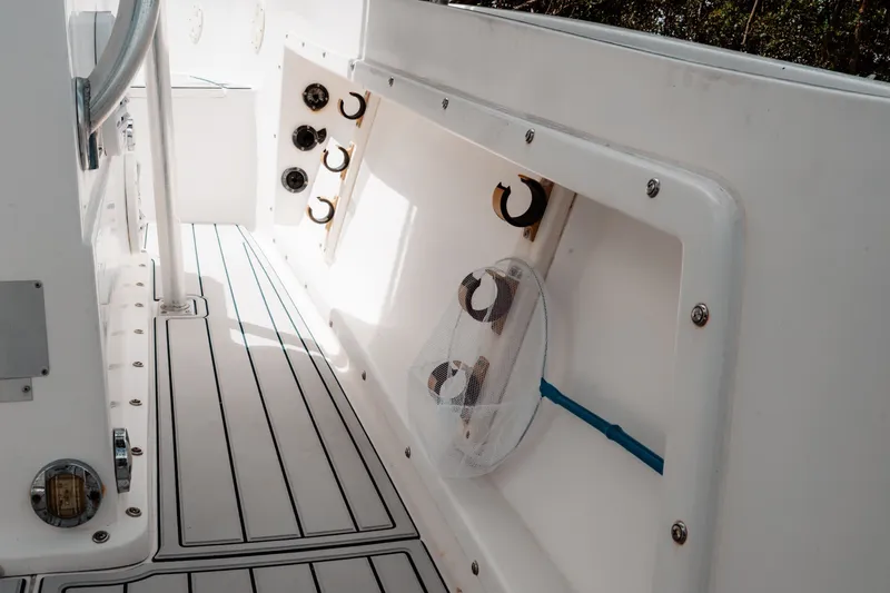 Slide: The Image of 1996 Mako 231 Center Console interior with rod holders and net storage. - 25