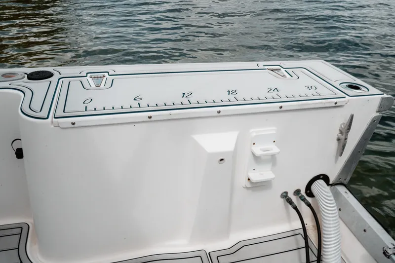 Slide: The Image of 1996 Mako 231 Center Console boat with measurement markings on deck by the water. - 37