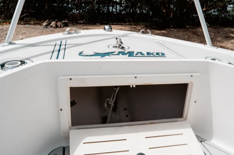 Slide: The Image of 1996 Mako 231 Center Console boat with open storage compartment and logo. - 30