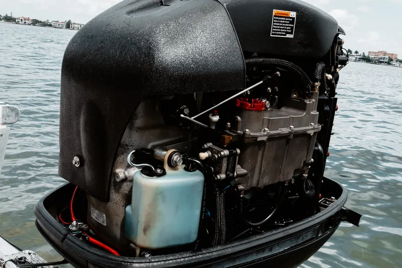 Slide: The Image of Outboard motor on a 1996 Mako 231 Center Console boat by the water. - 14