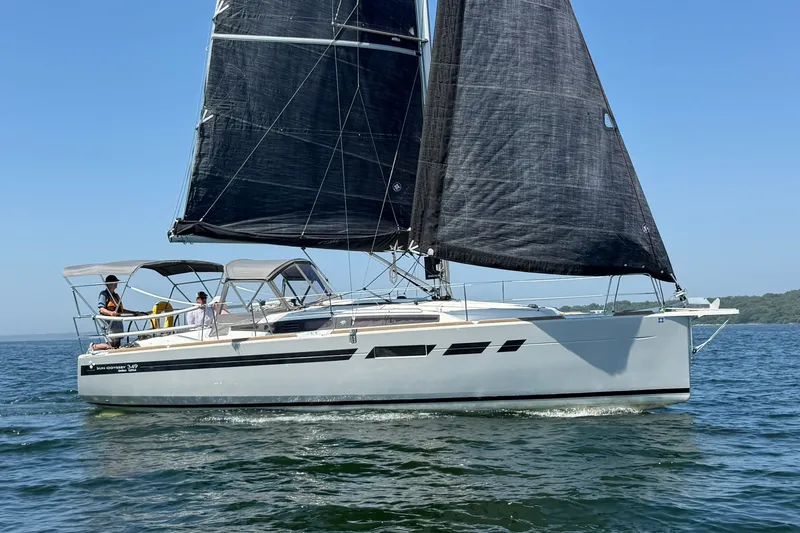 Slide: The Image of 2022 Jeanneau Sun Odyssey 349 Performance sailboat on open water, black sails, clear sky. - 14