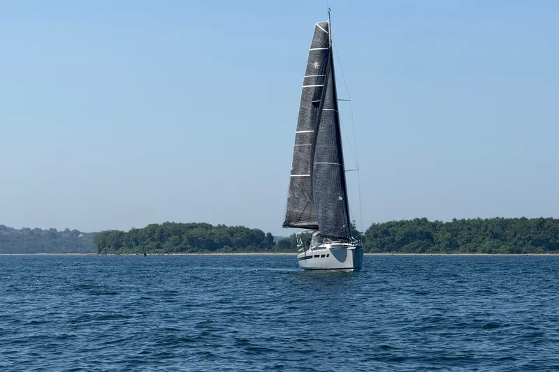 Slide: The Image of 2022 Jeanneau Sun Odyssey 349 Performance sailing near lush green island. - 11
