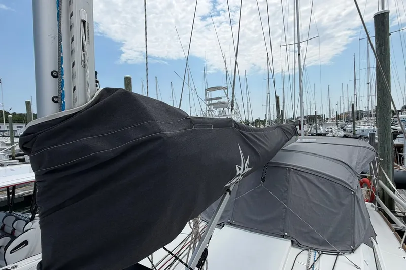 Slide: The Image of 2022 Jeanneau Sun Odyssey 349 Performance sailboat docked at marina, covered mainsail visible. - 30