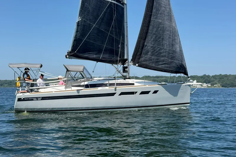 Slide: The Image of 2022 Jeanneau Sun Odyssey 349 Performance sailboat on calm water, with people onboard. - 53