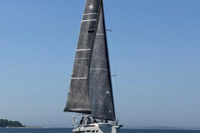 Slide: The Image of 2022 Jeanneau Sun Odyssey 349 Performance sailboat on open water under clear blue sky. - 25
