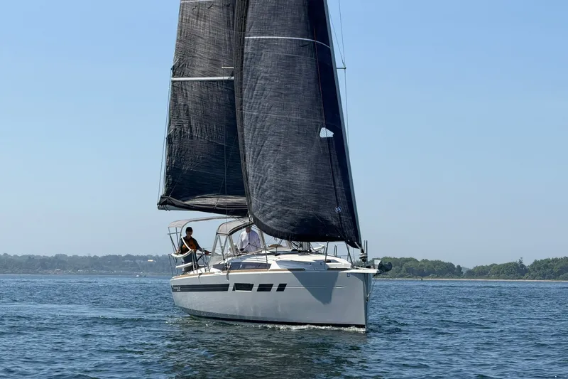 Slide: The Image of 2022 Jeanneau Sun Odyssey 349 Performance sailboat on open water, black sails, clear sky. - 35