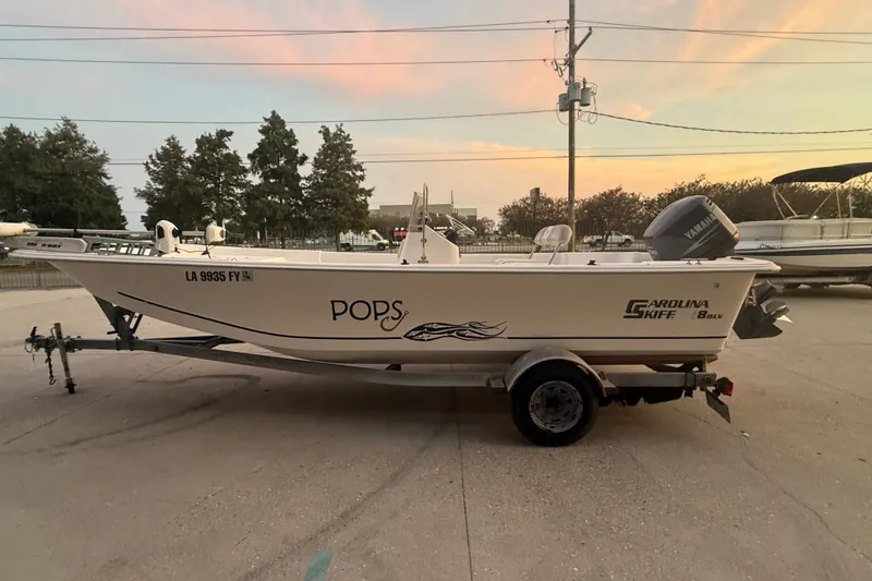 Slide: The Image of 2011 Carolina Skiff 218 DLV boat on trailer at sunset, featuring Yamaha motor. - 6