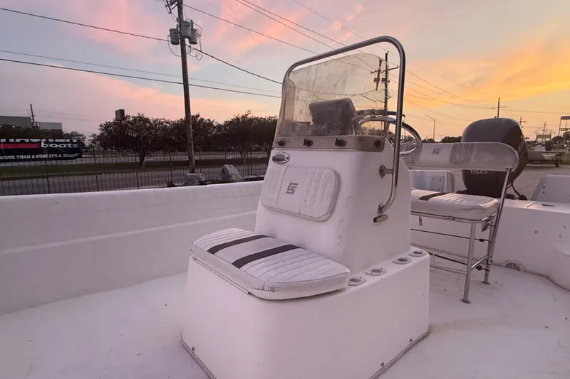 Slide: The Image of 2011 Carolina Skiff 218 DLV boat interior at sunset, featuring helm and seating. - 10