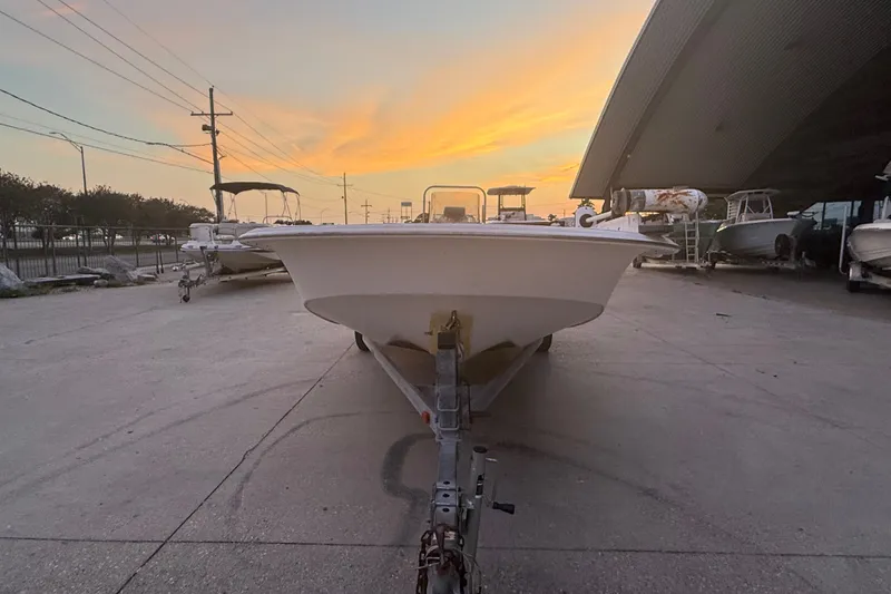 Slide: The Image of 2011 Carolina Skiff 218 DLV boat on trailer at sunset, parked outdoors. - 8