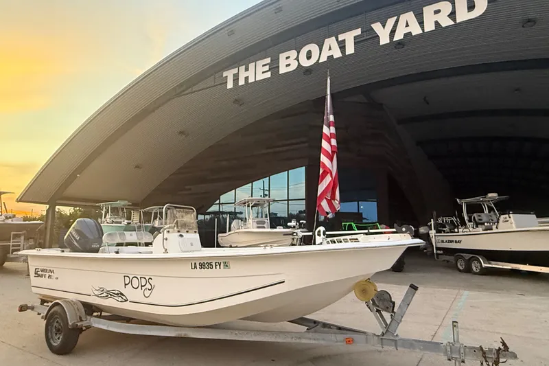 Slide: The Image of 2011 Carolina Skiff 218 DLV boat on trailer at The Boat Yard, sunset background. - 2