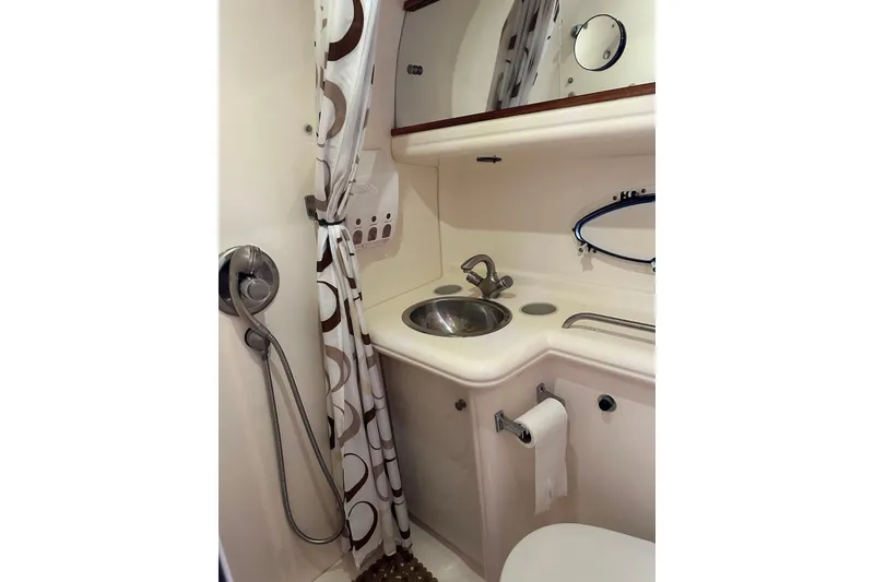 Slide: The Image of 2005 Larson Cabrio 310 boat bathroom with shower, sink, and mirror. - 7