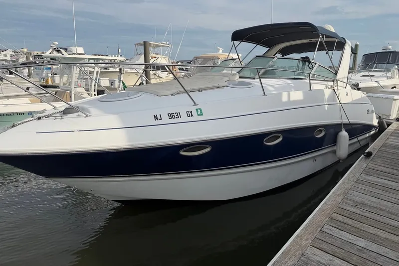 The Image of 2005 Larson Cabrio 310 boat docked at marina, featuring sleek design and blue hull. - 0