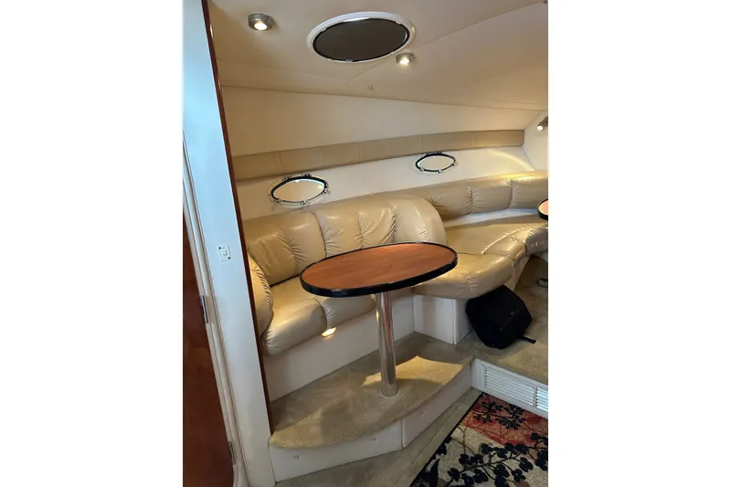 Slide: The Image of 2005 Larson Cabrio 310 interior with beige leather seating and oval windows. - 3